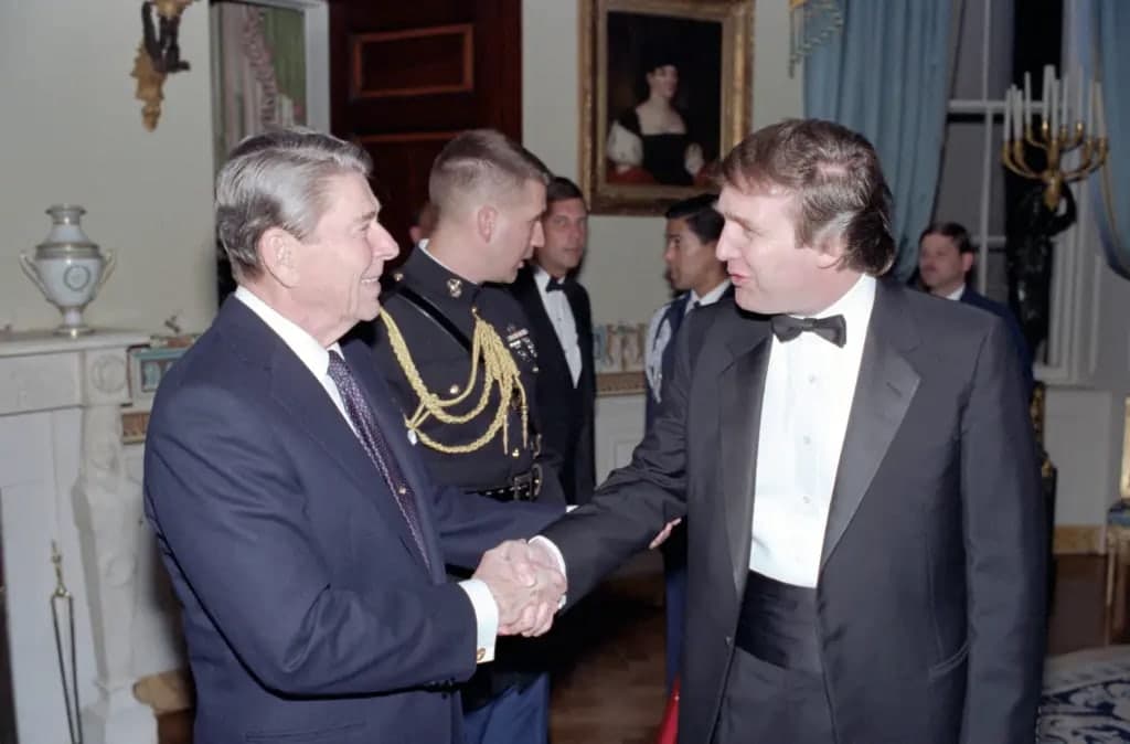 President Ronald Reagan shaking hands with a younger Donald Trump at a White House event