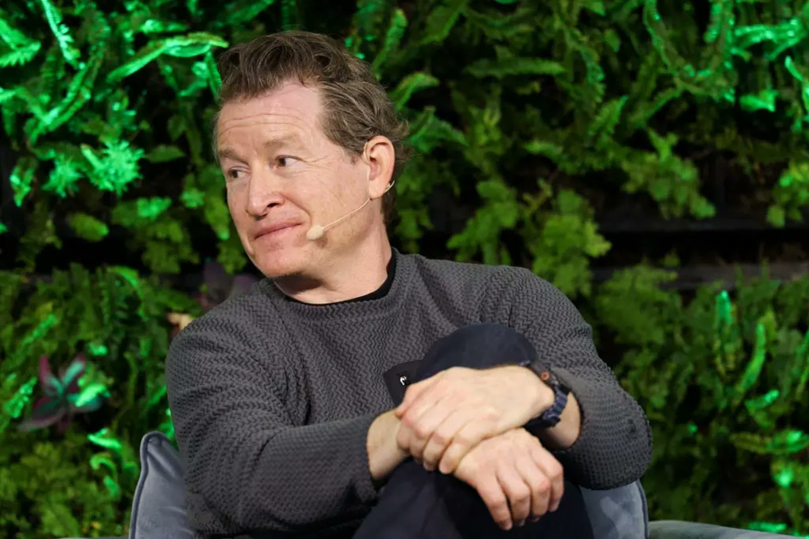 Patagonia CEO Ryan Gellert speaking on stage with a greenery backdrop