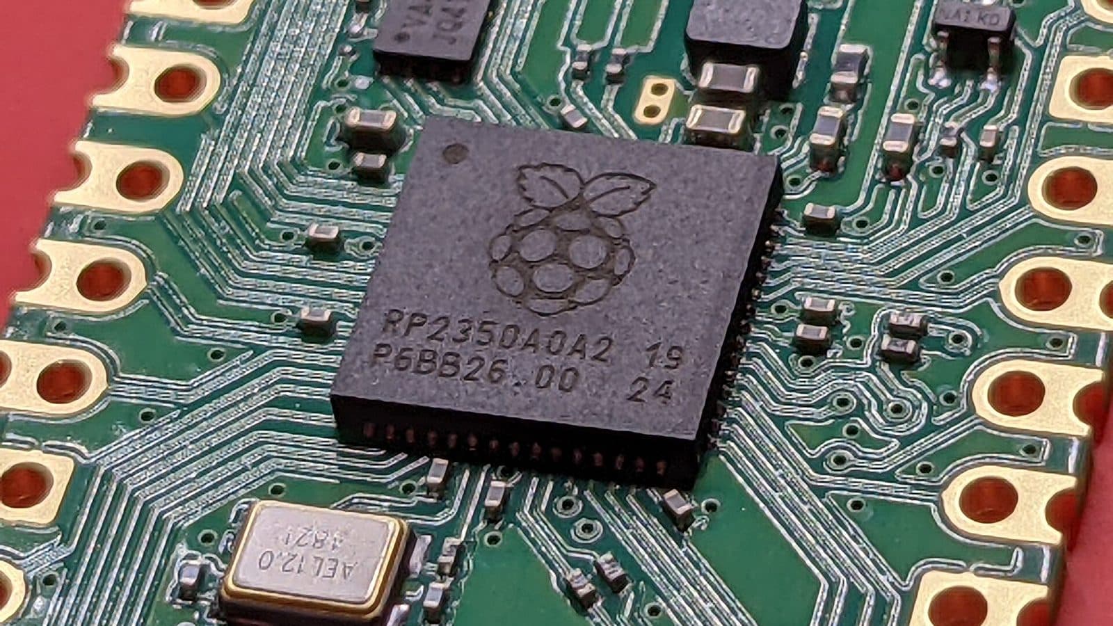 Macro photograph of a microcontroller chip soldered onto a green circuit board