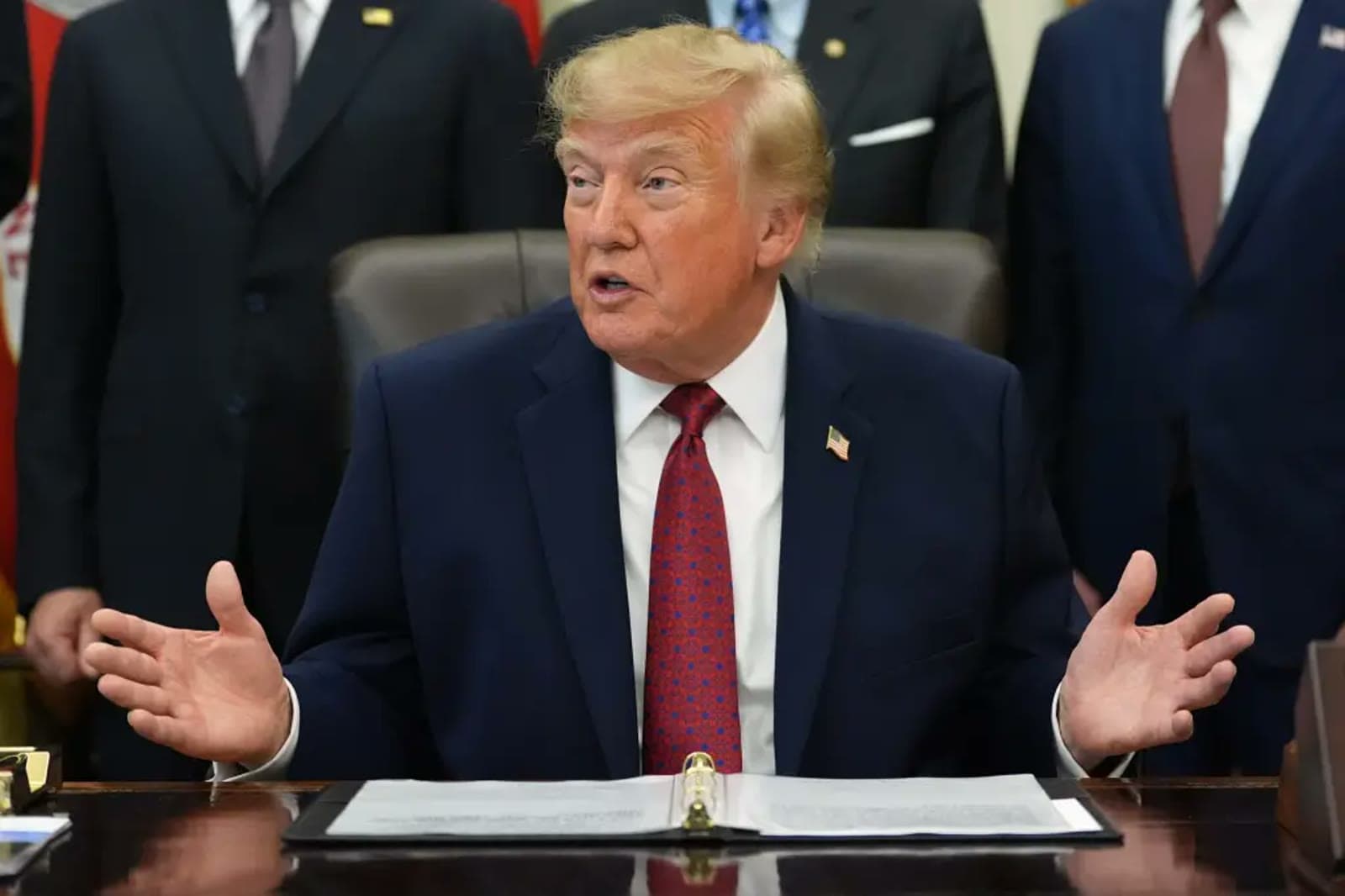 President Trump speaking with his hands raised during an Oval Office meeting